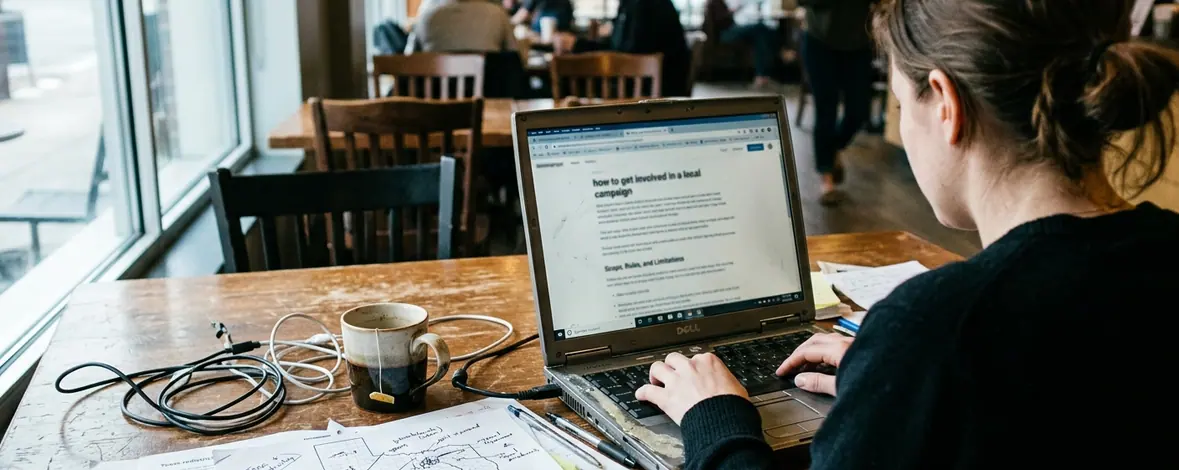 Candid shot of Coffee shop working environment capturing a smudged laptop screen displaying a blog